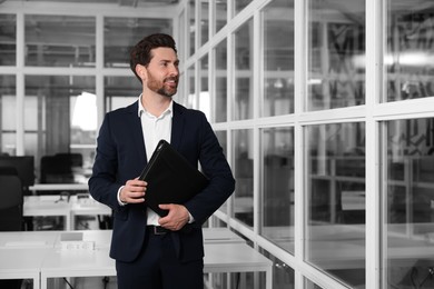 Photo of Male real estate agent with leather portfolio indoors