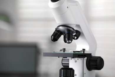 Modern medical microscope on blurred background, closeup with space for text. Laboratory equipment