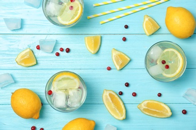 Photo of Flat lay composition with delicious natural lemonade on color wooden background