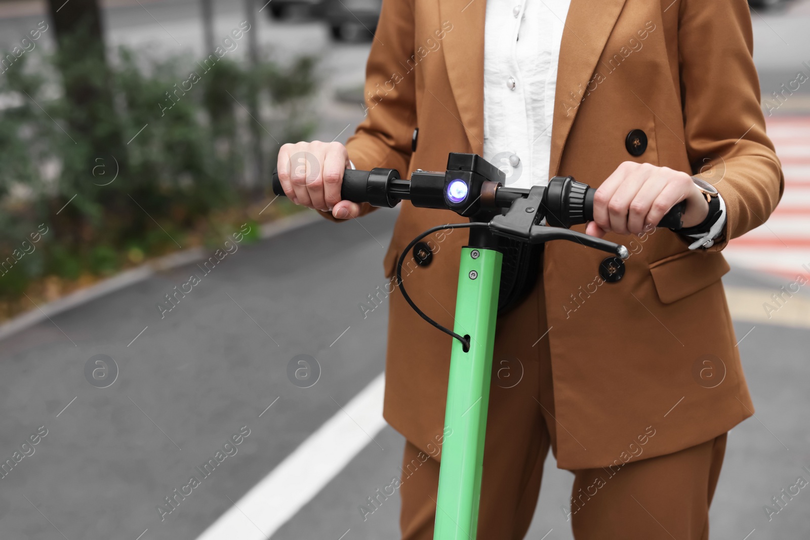 Photo of Businesswoman riding electric kick scooter on city street, closeup. Space for text