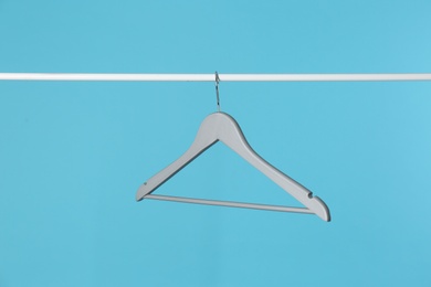 Photo of Metal rack with clothes hanger on color background