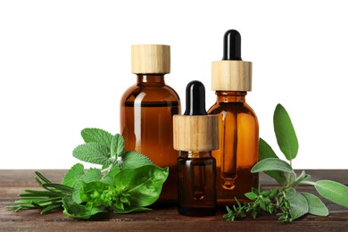 Bottles of essential oil and fresh herbs on wooden table against white background