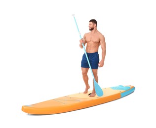 Happy man with paddle on orange SUP board against white background