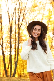 Photo of Beautiful happy woman wearing hat in park. Autumn walk