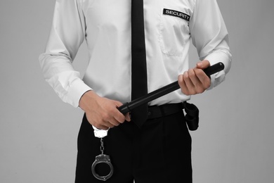 Photo of Male security guard with police baton on color background