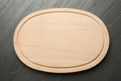 Photo of One wooden cutting board on dark grey table, top view