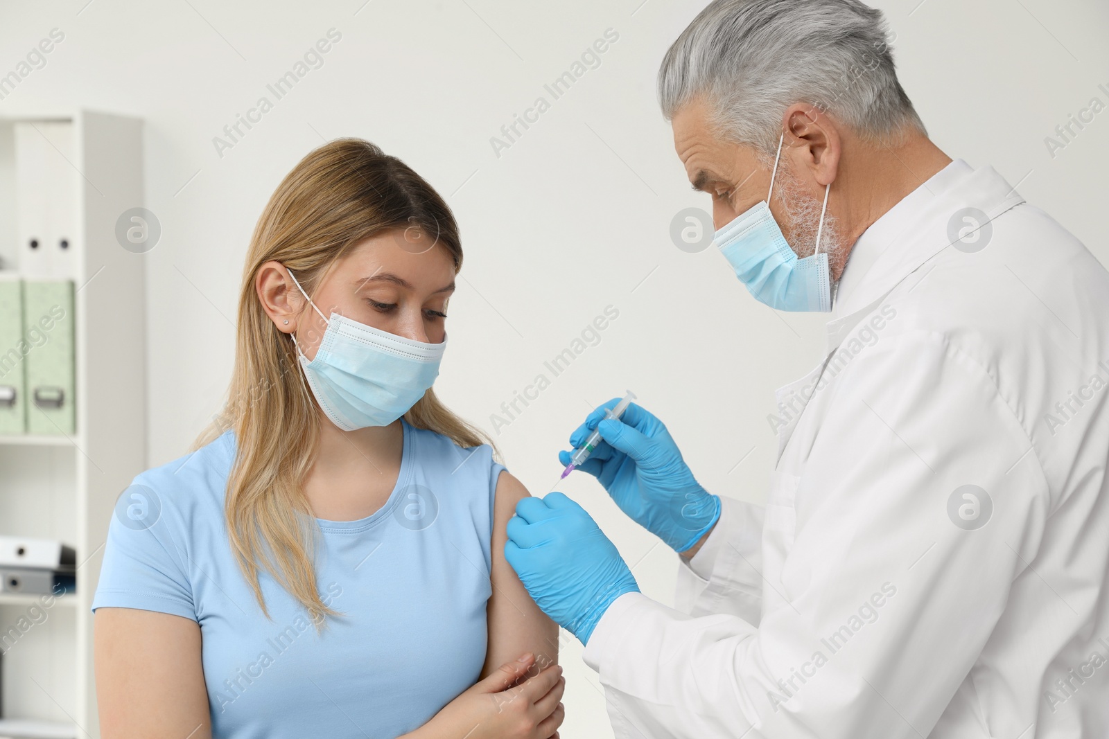 Photo of Doctor giving hepatitis vaccine to patient in clinic