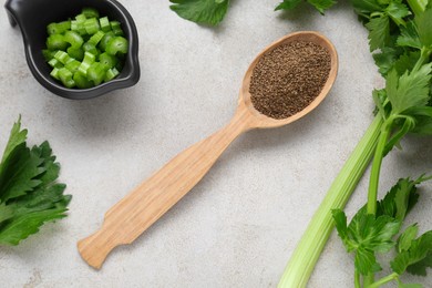 Spoon of celery seeds and fresh plant on light grey textured table, flat lay