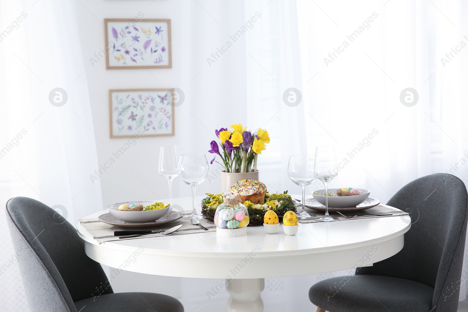 Photo of Festive Easter table setting with beautiful flowers and eggs indoors