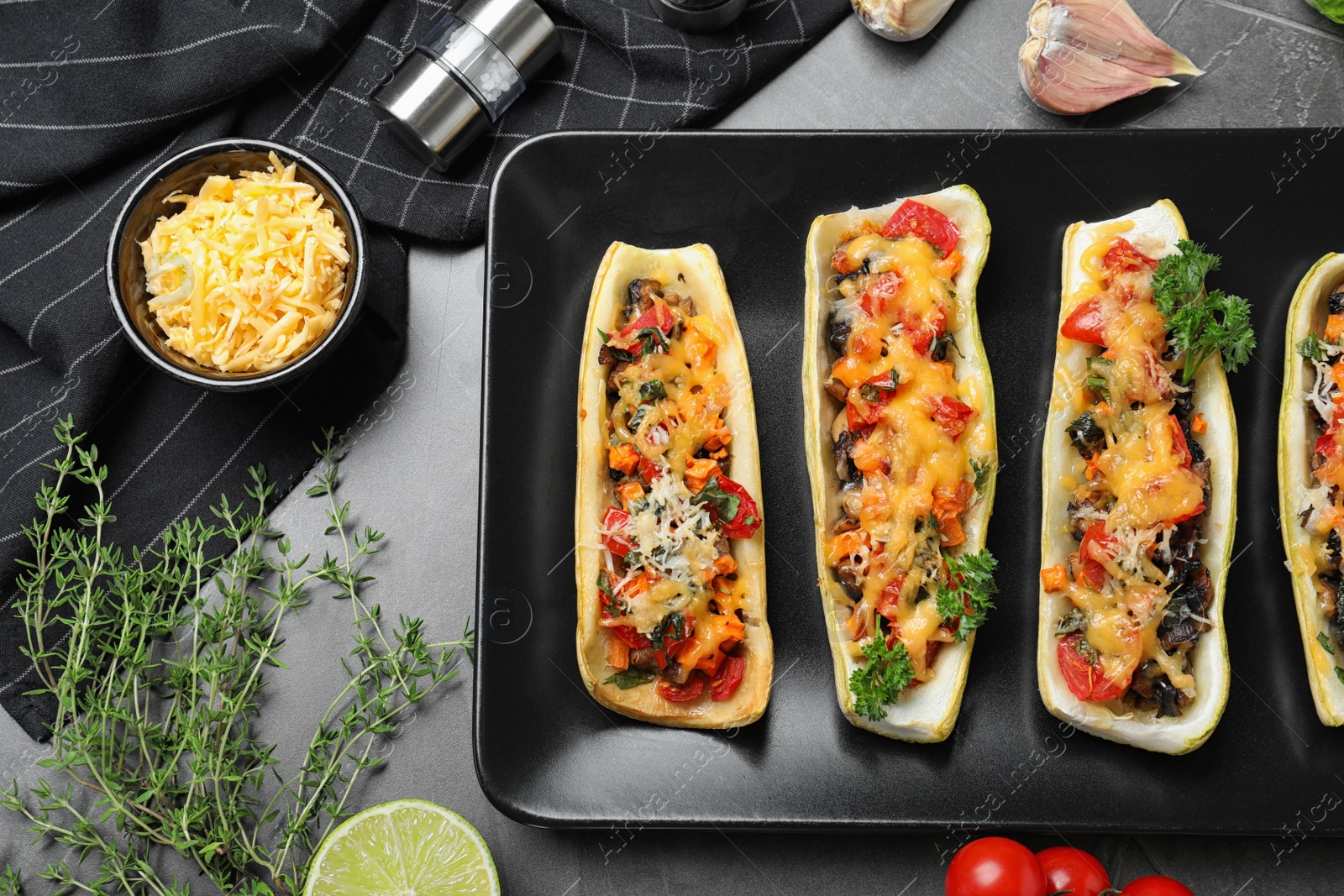 Photo of Flat lay composition with delicious stuffed zucchini on grey table