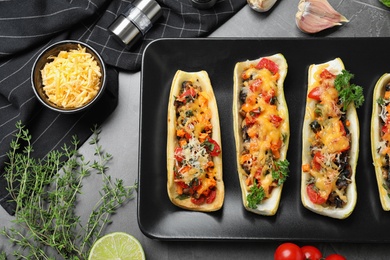 Flat lay composition with delicious stuffed zucchini on grey table