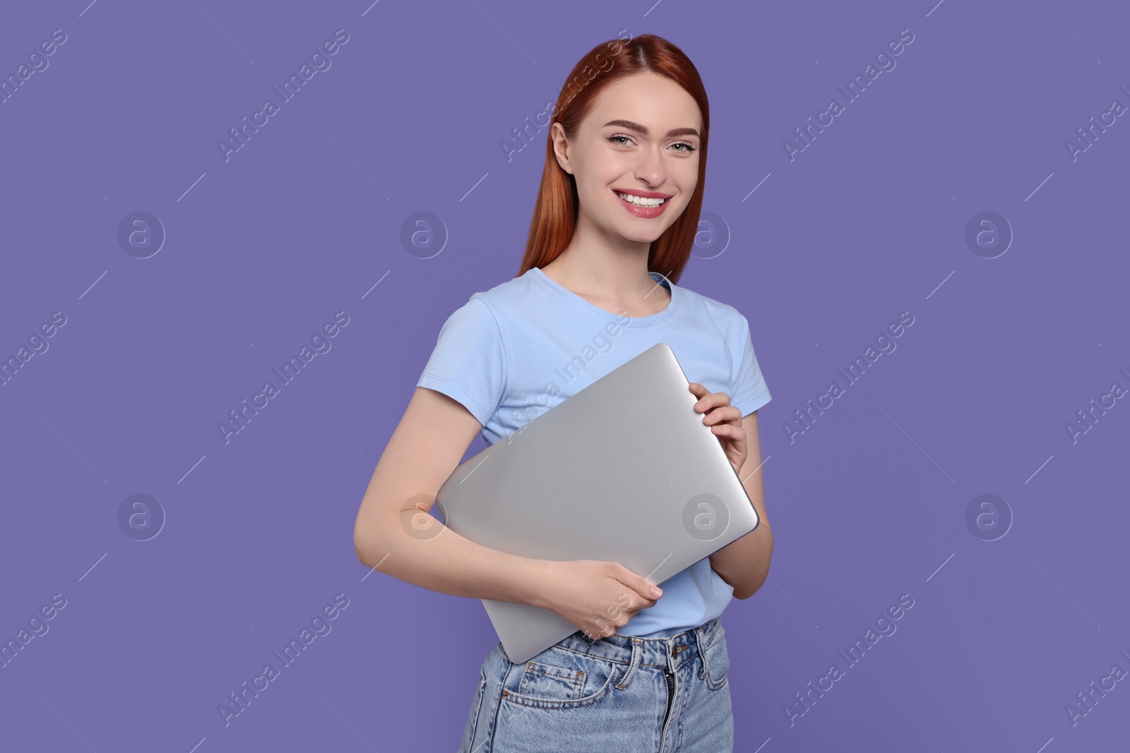 Photo of Smiling young woman with laptop on lilac background