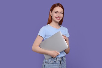 Photo of Smiling young woman with laptop on lilac background