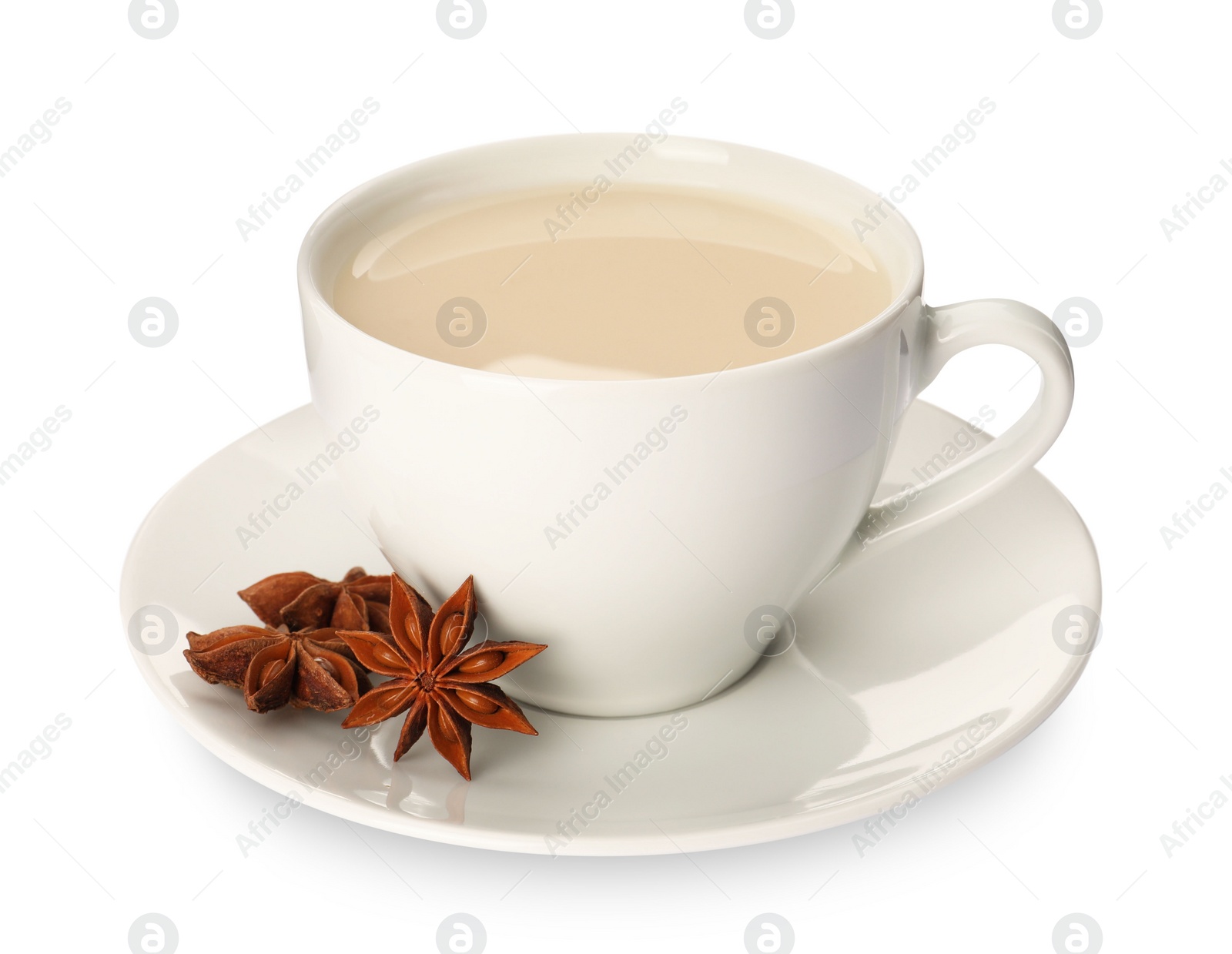 Photo of Cup of tea with milk and anise stars on white background