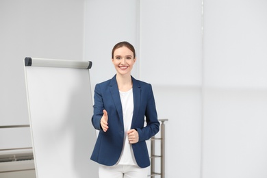 Photo of Professional business trainer near flip chart board indoors. Space for text