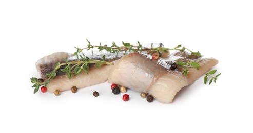 Photo of Delicious salted herring fillets with thyme and peppercorns on white background