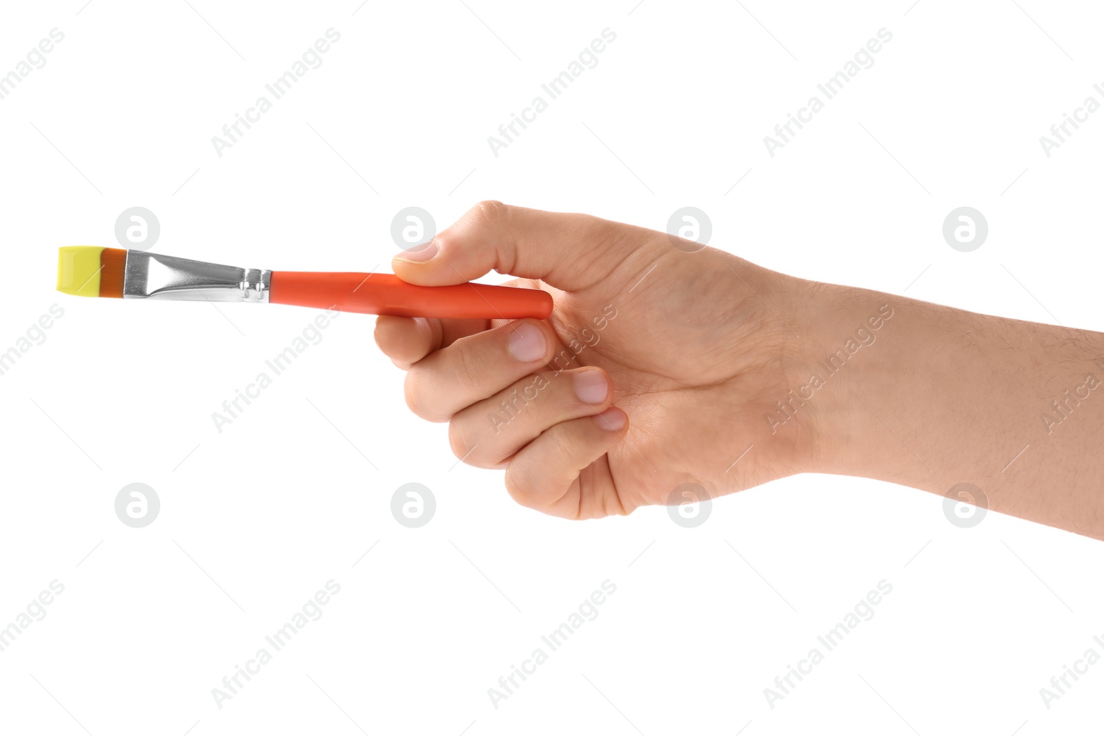 Photo of Young man holding brush with color paint on white background, closeup