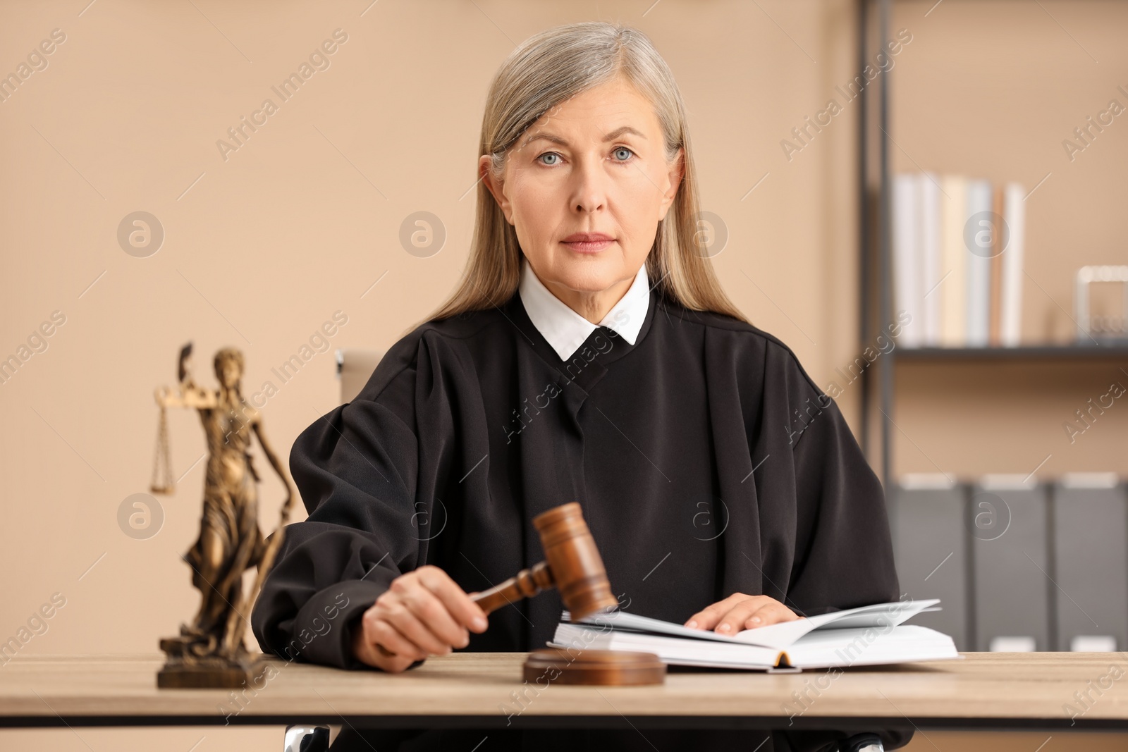 Photo of Judge striking mallet at wooden table indoors