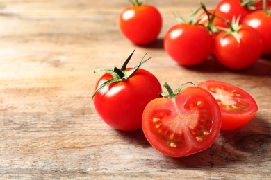 Photo of Fresh cherry tomatoes on wooden background. Space for text