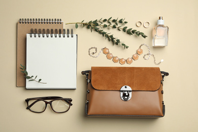 Photo of Flat lay composition with stylish woman's bag and accessories on beige background