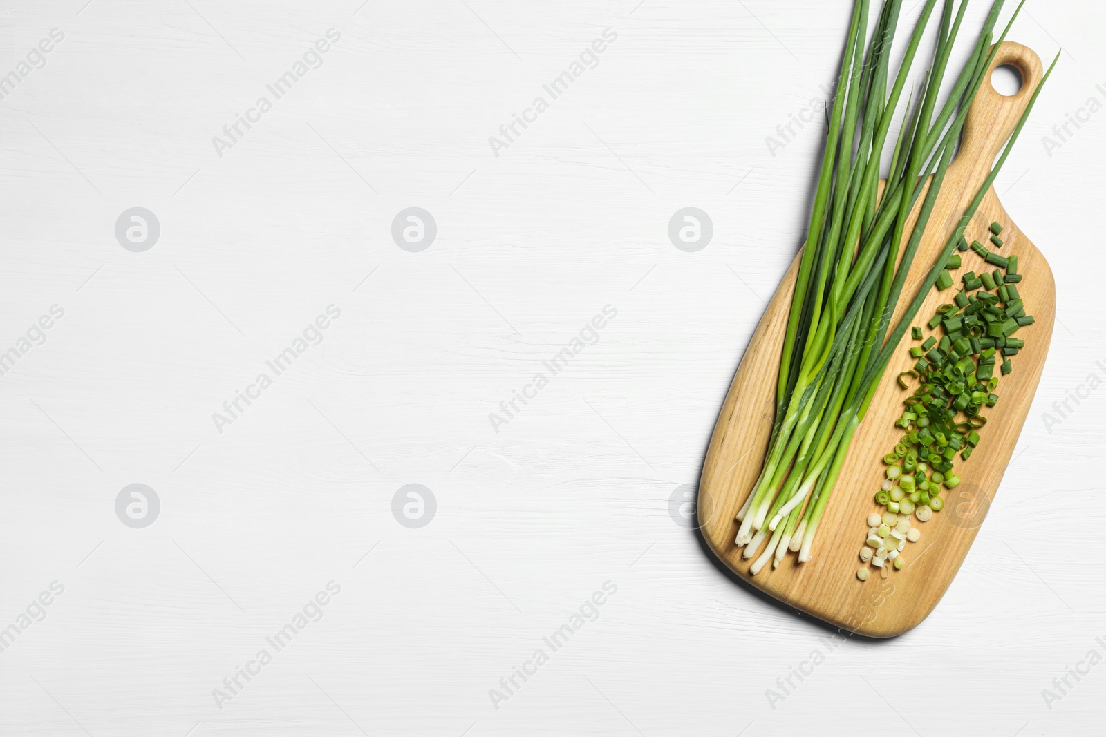 Photo of Fresh green onion on white wooden table, top view. Space for text