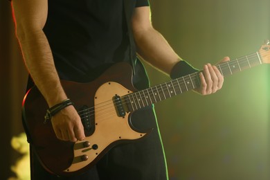 Man playing electric guitar on stage, closeup. Rock music
