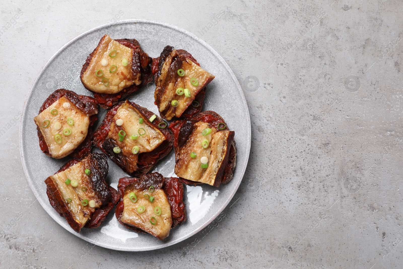 Photo of Tasty sandwiches with fried pork fatback slices on grey table, top view. Space for text