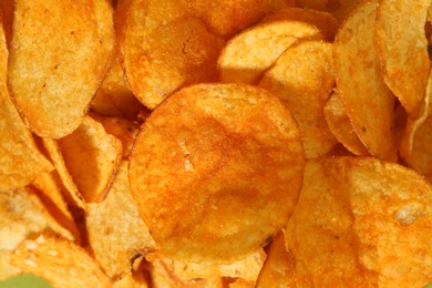 Photo of Crispy potato chips as background, closeup view