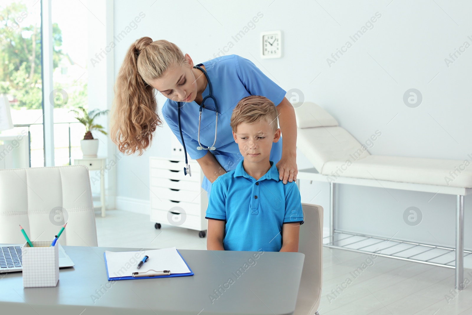 Photo of Female medical assistant examining child in clinic