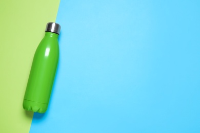 Photo of Green bottle on color background, top view. Space for text