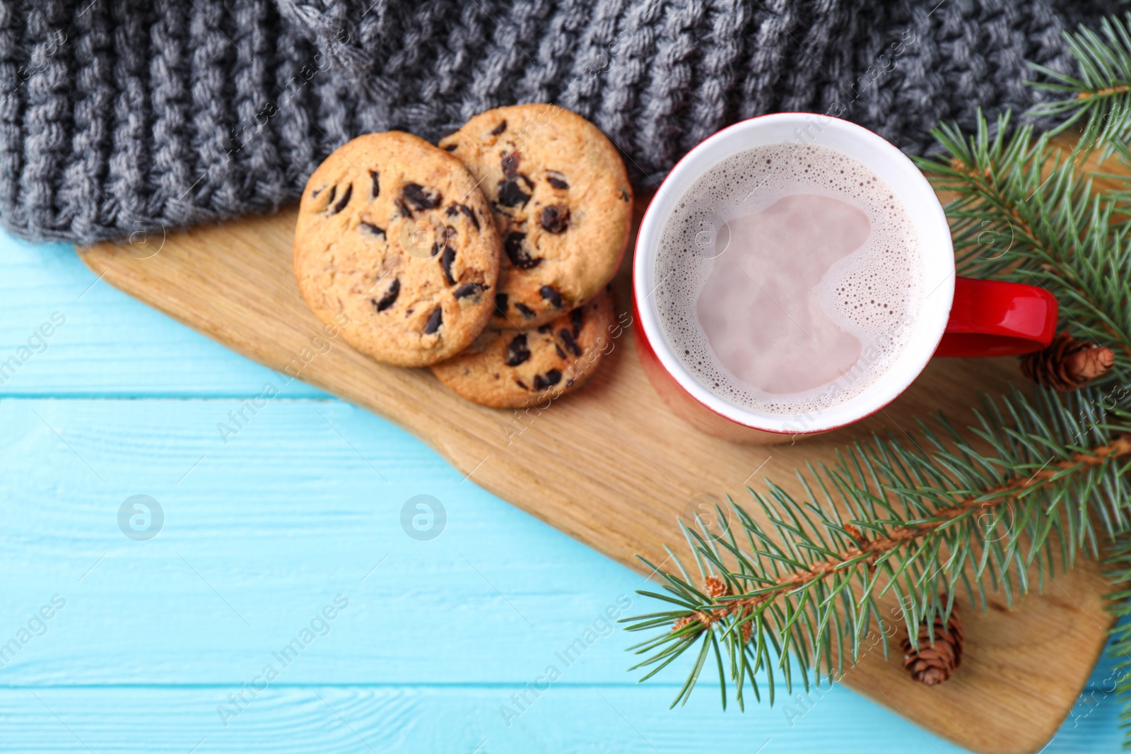 Photo of Flat lay composition with cup of tasty cocoa on blue wooden table. Space for text