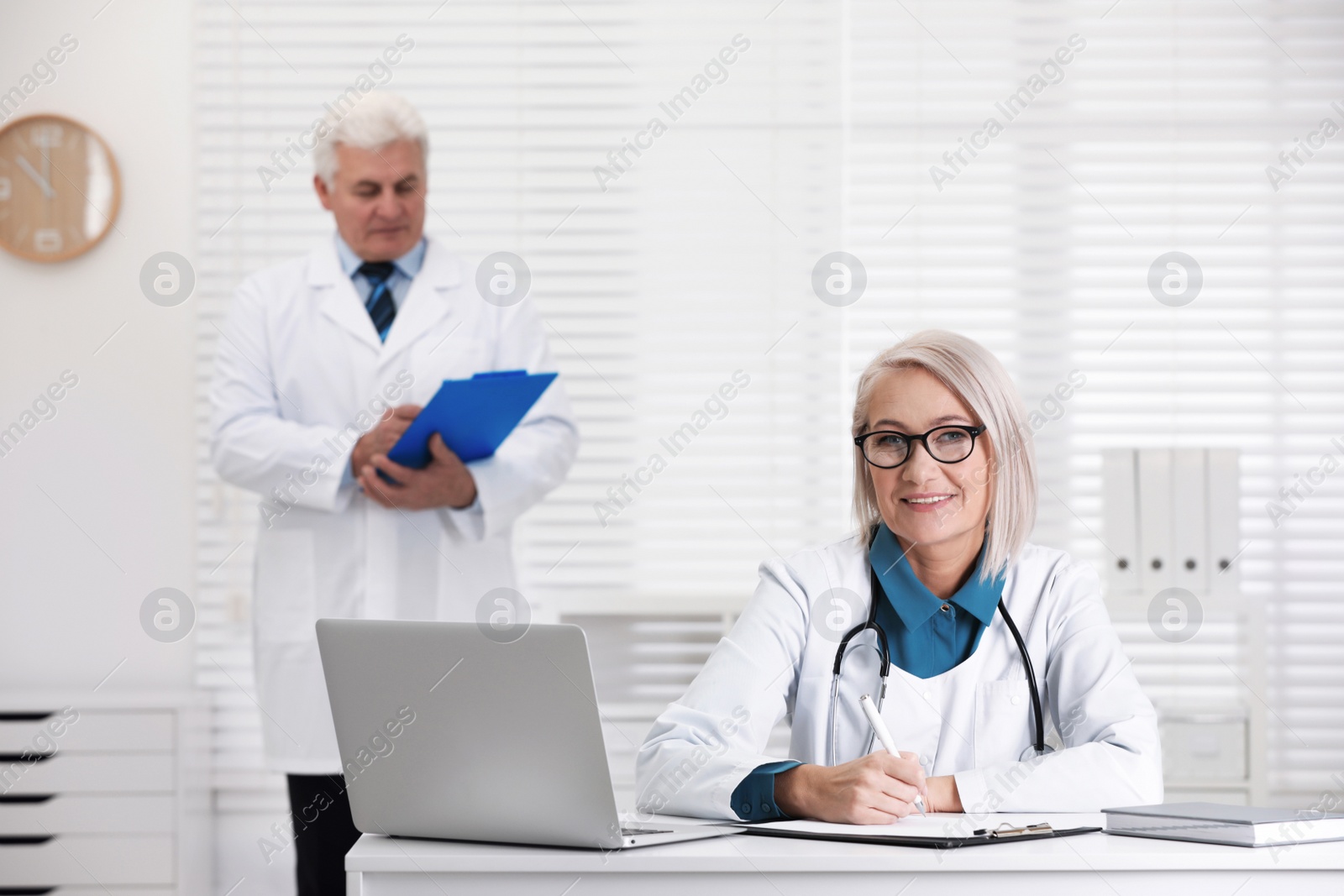 Photo of Portrait of mature female doctor in white coat at workplace