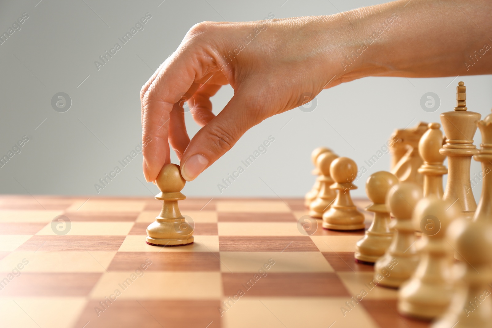 Photo of Woman moving chess piece on board, closeup