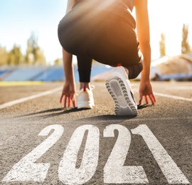 Image of Start new year with fresh vision and ideas. Sporty woman ready for running near 2021 numbers on road, closeup