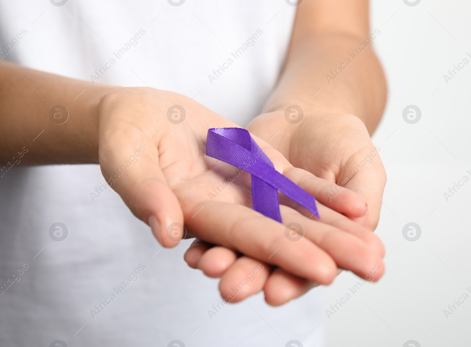 Photo of Woman holding purple ribbon on white background, closeup. Domestic violence awareness