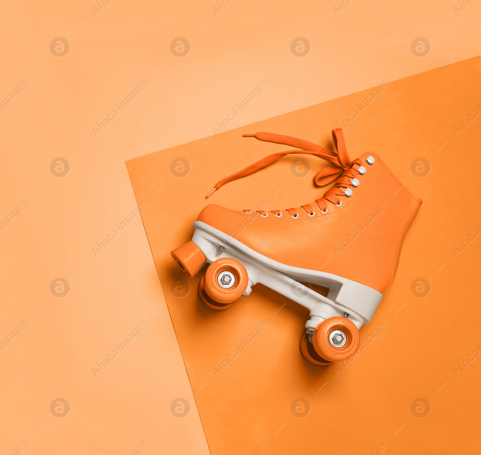 Image of Stylish quad roller skate on orange background, top view