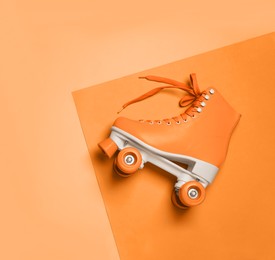 Image of Stylish quad roller skate on orange background, top view