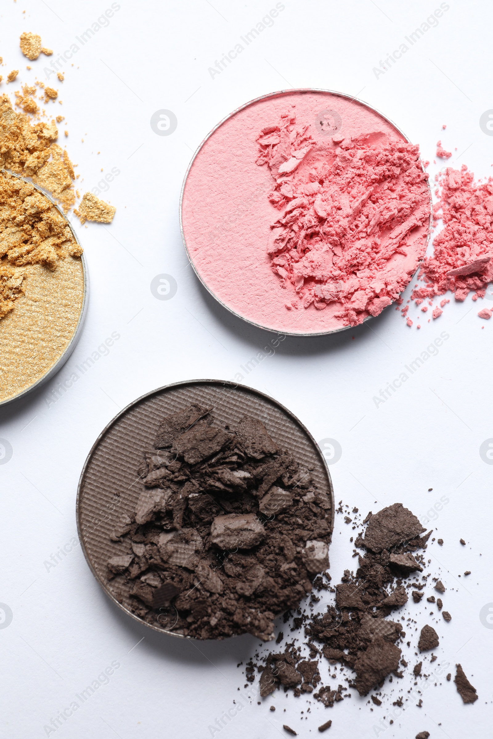 Photo of Different crushed eye shadows on white background, flat lay. Professional makeup product