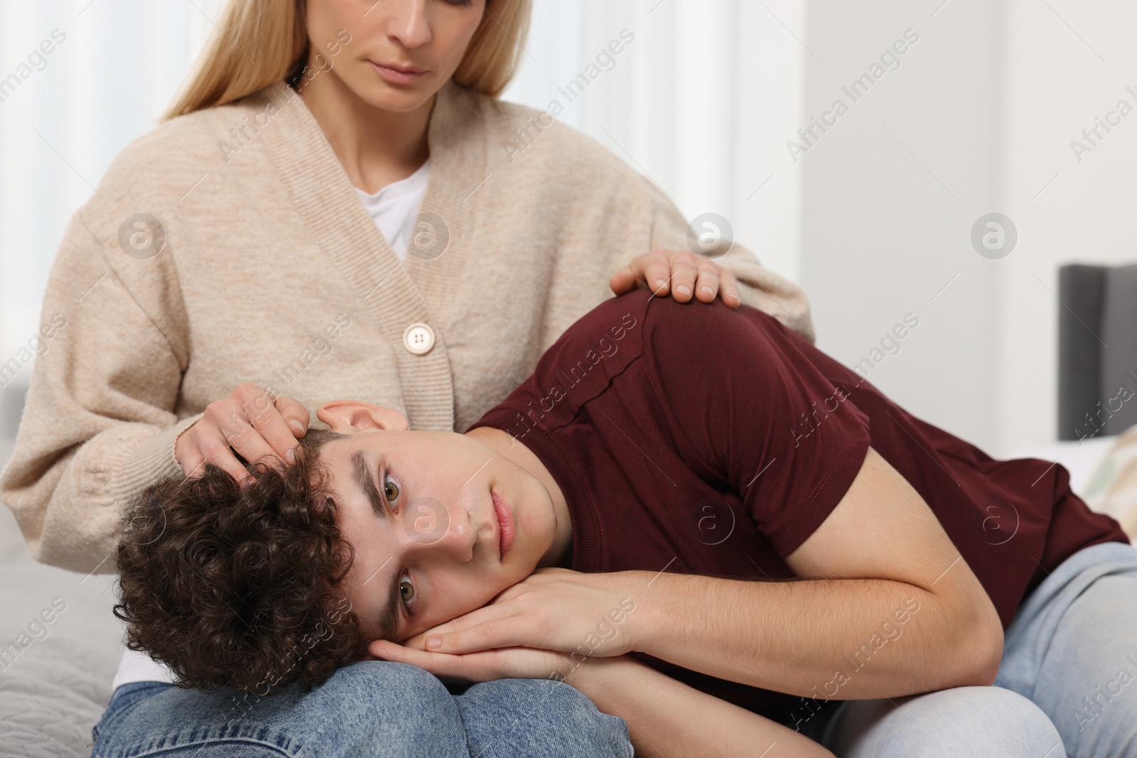 Photo of Mother consoling her upset son at home. Teenager problems