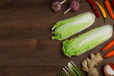 Photo of Flat lay composition with fresh Chinese cabbages and ingredients on wooden table. Space for text