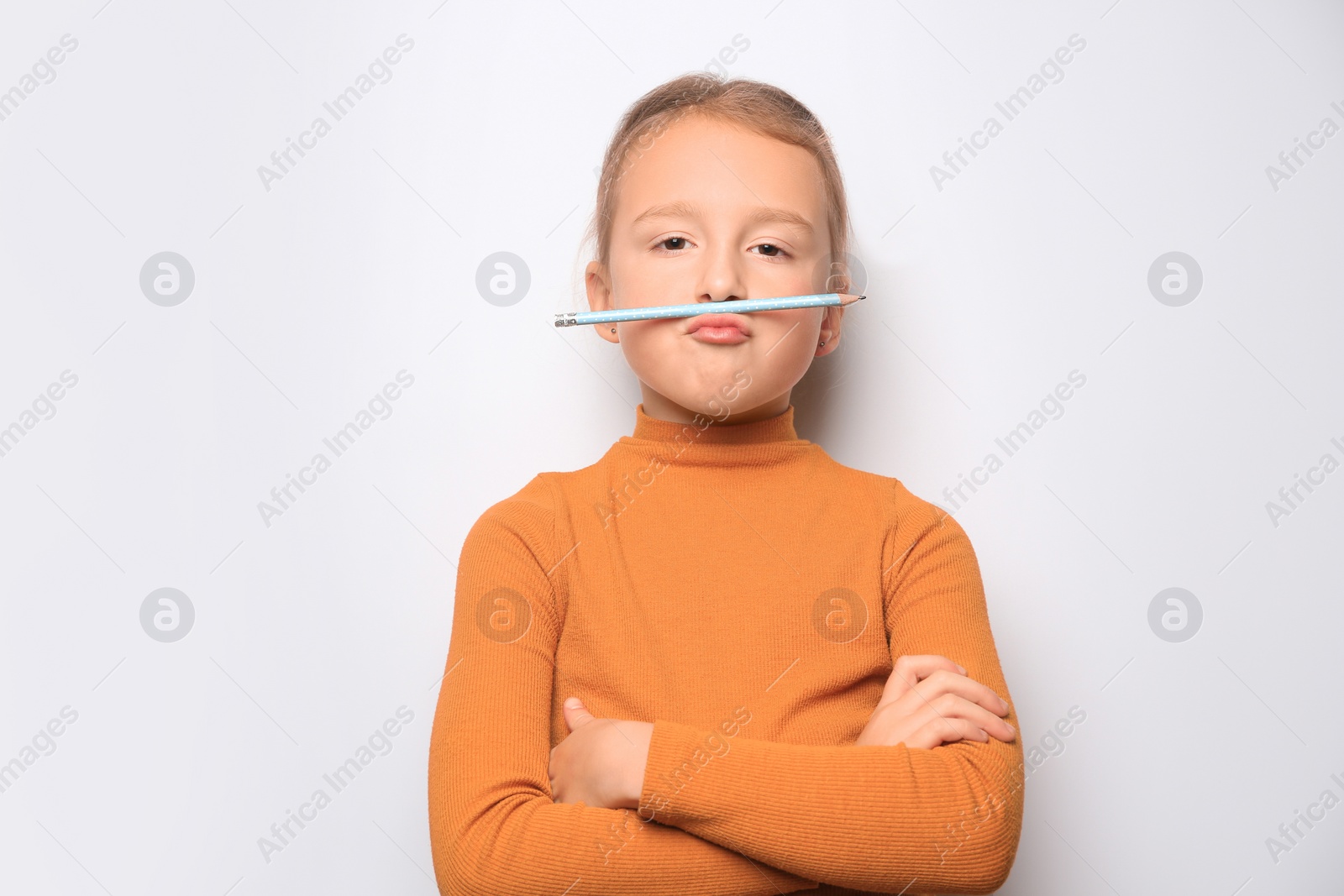 Photo of Funny little girl with pencil on white background
