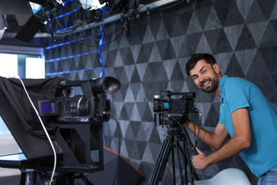 Photo of Professional video camera operator working in studio