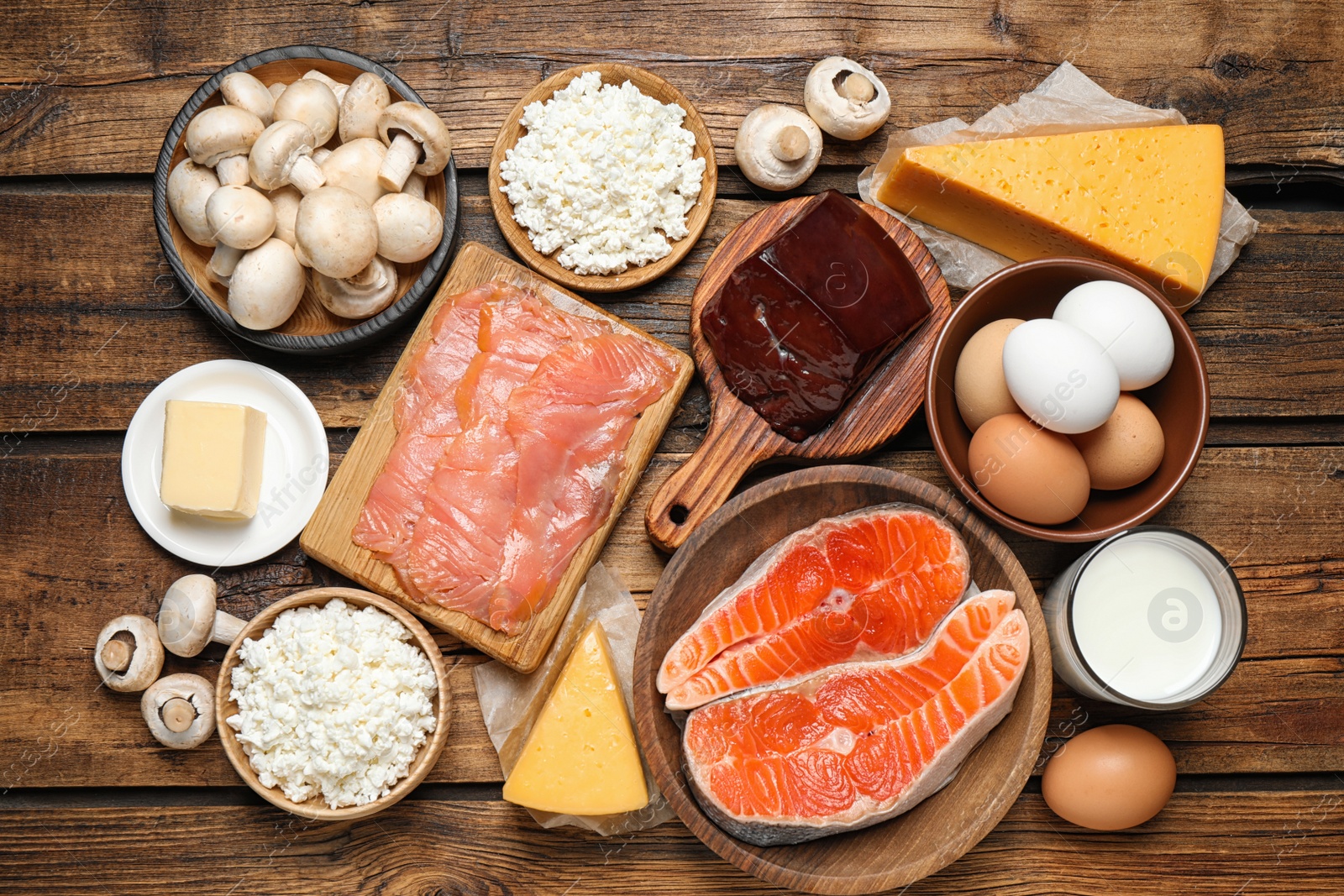 Photo of Fresh products rich in vitamin D on wooden table, flat lay