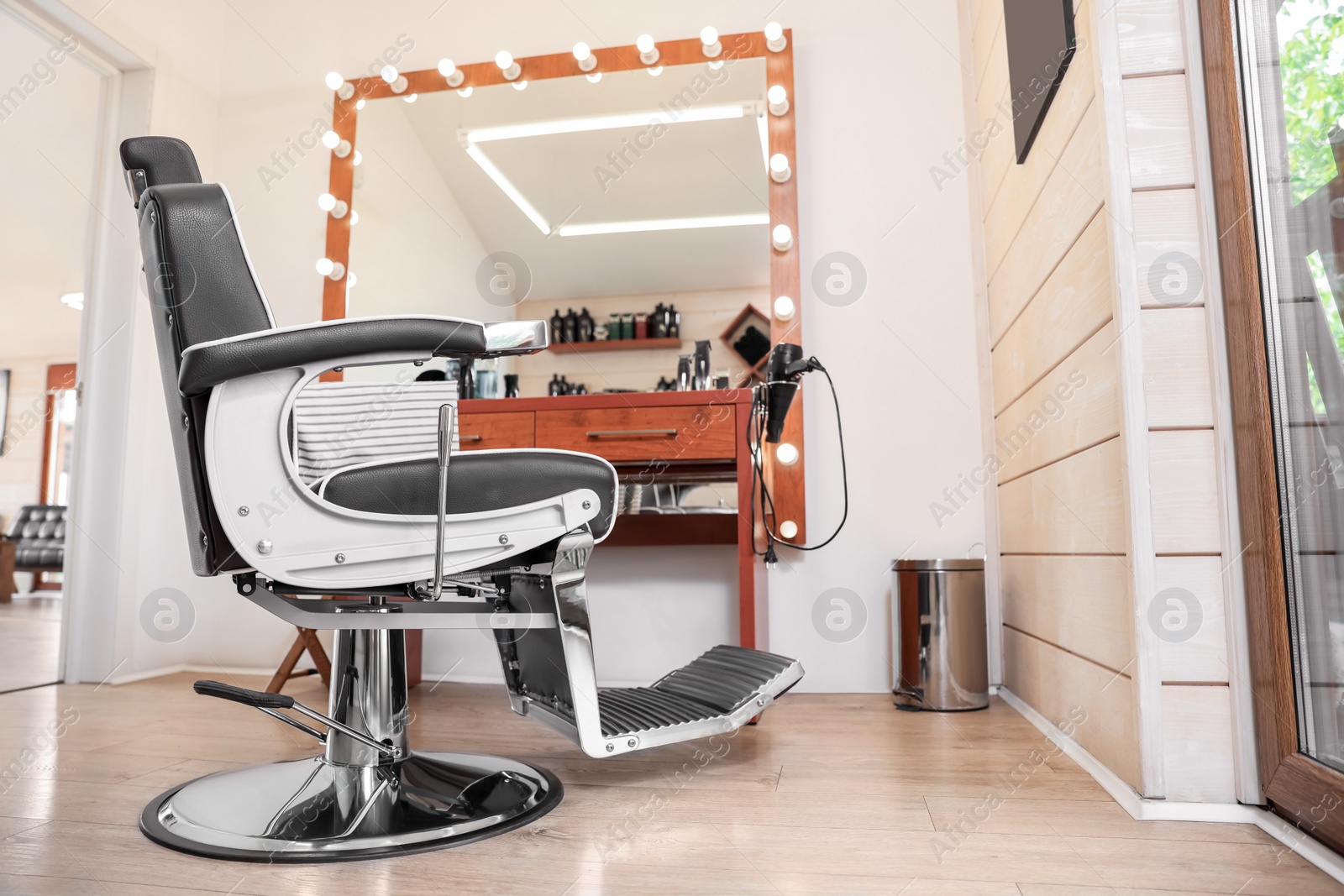 Photo of Stylish hairdresser's workplace with professional armchair in barbershop. Interior design