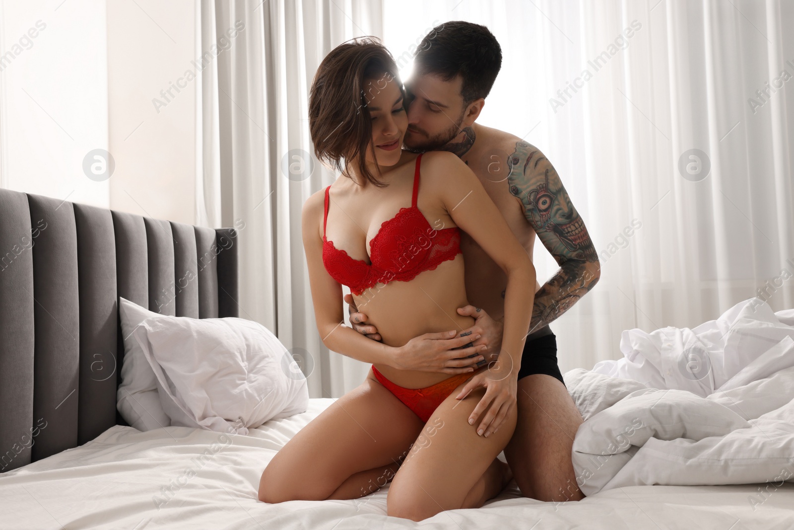 Photo of Passionate couple having sex on bed at home