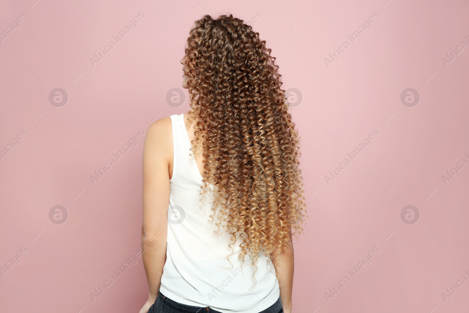 Photo of Beautiful young woman with shiny wavy hair on color background