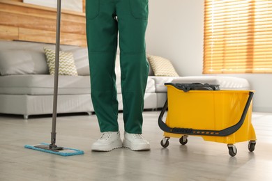 Woman cleaning floor with mop at home, closeup