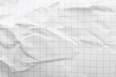 Photo of Crumpled checkered notebook sheet as background, top view