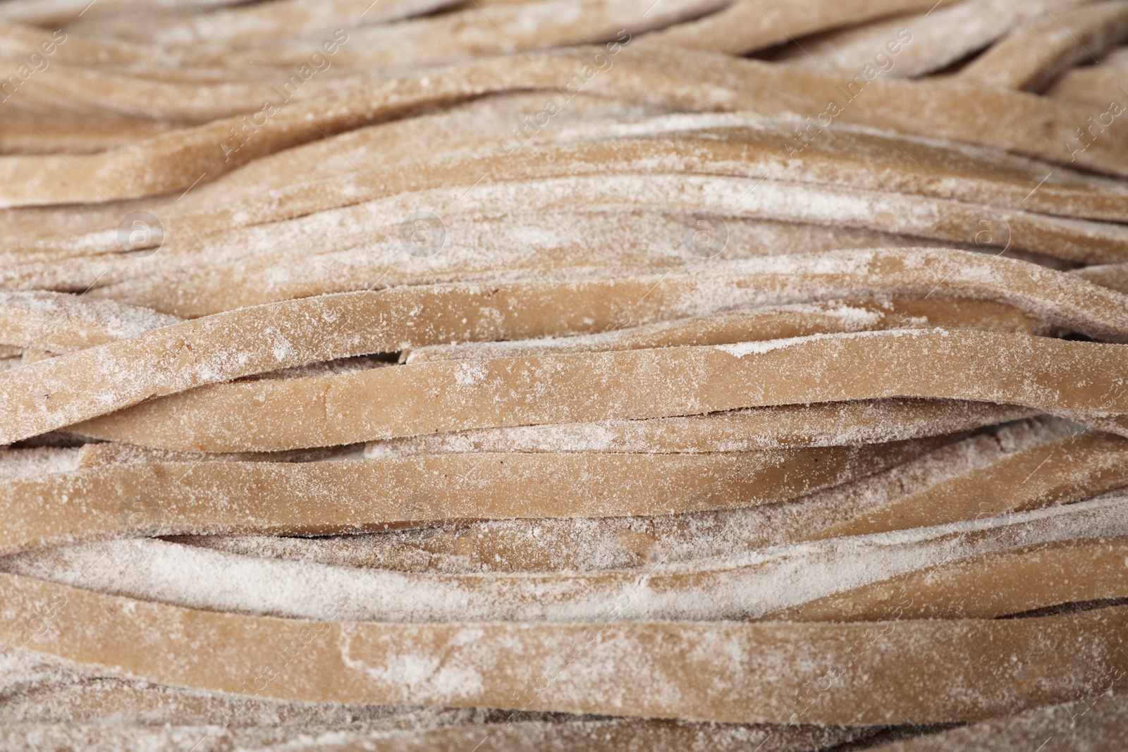 Photo of Uncooked homemade soba (buckwheat noodles) as background, closeup