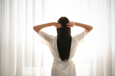 Young woman near window at home. Lazy morning